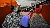 K.C. Skillern, en av de ansatte til We Recycle Solar, bruker en liten spade til å flytte materialer som er hentet ut av kasserte solcellepaneler.