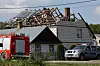 Brannfolk arbeider med det ødelagte taket til et hus som har blitt truffet av en flygende gjenstand i forbindelse med det russiske droneangrepet 10. september. Men det er ikke sikkert det var en drone som ødela taket.
