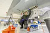 Lærlingen Vetle ser opp i den fremre hjulbrønnen på F-16 flyet i lærlinglaben på Ørland. Foto: Arash A. Nejad
