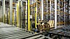 På høytlageret er det 65.000 palleplasser. Pallene løftres til og fra rullebåndet av 11 kraner, én for hver mast. Hver kran betjener 120 meter med reoler.