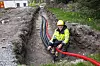 – Vi har lagt ut cirka 8000 meter med rør i forbindelse med energibrønnene på UiS, sier Knut Kasin fra Rototec. De svarte rørene fører kjølemediet inn/ut av energibrønnene. Det røde røret er et trekkrør for kabel som skal gå til temperaturfølere i hver samlekum. De to røde ledningene er fiberkabel som skal ned til bunnen av de ti forskningsbrønnene. Foto: Alf Bergin
