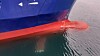 De utfoldbare baugvingene skimtes i vannet. MF Teistin vil spare rundt 10 prosent drivstoff med foiler, ifølge Wavefoil.