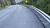 Etter-bildet viser et slett asfaltdekke med rekkverk montert i en solid skråning.