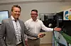 Daglig leder i konsulentselskapet Vivende, Steinar Koffeld (t.v) og Aleksander Mortensen, direktør for Tomra Collection Solutions Digital, ved samme type automater som er utplassert i Australia. Vivende har bidratt med utbetalingsløsninger til forbrukerne. Foto: Tore Stensvold
