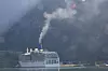 Cruiseskip ved kai i Flåm. Eksosen legger seg som en blåhvit dis. Foto: Tore Stensvold