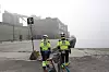 Merete Lund Østby og Bjørn Tore Orvik på kaiområdet. Lagerbygget i bakgrunnen skal rives. Kaia blir mellomlagringsplass for containere. Skinnegående gantrykran skal laste og losse autonomt.