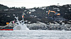 Det pågår arbeider i land rett ved der fregatten KNM Helge Ingstad ligger. En gravemaskin legger på plass sprengmatter oppå fjellet og det er trukket gule tau ut til akterenden av havaristen som så vidt stikker opp av vannet. Foto: Tore Meek / NTB scanpix