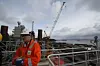 GASSER PÅ: Skarv har fire gassturbiner, hver på 32 MW. Mest kraft går med til gasskompresjon for transport i rørledning til Åsgard.Det skal likevle ikke være nødvendig å kjøre alle fire samtidig. Eksosrørene stikker opp bak Jon-Petter Pedersen.