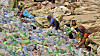 Pakistanske arbeidere sorterer tomme plastflasker ved en resirkuleringsfabrikk i Hyderabad.