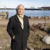 Hans Olav Tangen på stranda hvor bryggene med de flytende boligene skal ligge. «Mosseferja» i bakgrunnen. Foto: Knut Bjørheim