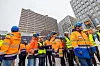 Medarbeidere i Skanska og Statsbygg feirer byggestarten. I bakgrunnen noen av blokkene som begynner å bli ferdige, fv. Høyblokka, hjørnet av A-blokka og D-blokka. Foto: Arash A. Nejad