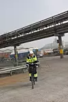 Merete Lund Østby, prosjektleder for autonomi på landsiden hos Yara på Herøya kommer på sykkel ned til kaiområdet. Portalkranene må tilpasses slik at de kommer under rørgatene. Foto: Tore Stensvold