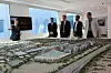Den norske delegasjonen skuer ut over modellen av Expo 2020 i Dubai. I bakgrunnen teller klokken ned: 108 uker igjen til åpningen. Foto: Jan Moberg