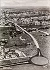 Det var liksom ikke måte på i Fredrikstad på 1950-tallet. Samtidig med den nye brua kom også en annen hypermoderne trafikkløsning: en av landets første skikkelige rundkjøringer. Bildet er trolig tatt mellom mellom 1957 og 1960. Foto: Nasjonalbibliotekets samling/Wikimedia Commons