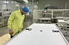 Anders inspiserer tilkoblingene på baksiden av et modul i en av fabrikkene. Foto: Solcellespesialisten