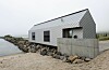 Det nye servicebygget er langstrakt, med en form hentet fra tradisjonelle sjøhus på Senja. Arkitekt: Nordic Office of Architecture.