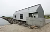 Det nye servicebygget er langstrakt, med en form hentet fra tradisjonelle sjøhus på Senja. Arkitekt: Nordic Office of Architecture.