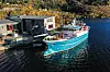 «Skulebas» til kai i hjemmehavnen i Deknepollen på Måløy. Elevene på dekk er matroselever på andre året i videregående opplæring. De fikk undervisning i fortøyning da bildet ble tatt. Bygget på kaia er Fagskulen Vestland avdeling Måløy, der det blant annet er navigatørutdanning. Også navigatørene bruker fartøyet til opplæring. Hydrogentankene skal plasseres på det åpne området på dekk, mellom elevene og styrehuset.