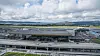 Terminal 3 ved Bergen lufthavn Flesland. En bro foran terminalen frakter reisende til og fra. I bakgrunnen den eksisterende terminal 2. Foto: Eirik Helland Urke
