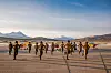 Flyaspiranter ved Luftforsvarets flygeskole på Bardufoss flystasjon danser til BlimE-sangen. Tre skolefly står i bakgrunnen. Foto fra 2020.