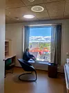 Journalisten prøvesitter pasientrommenes dype vinduskarmer. Foto: Kari Hornmoen