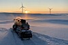 Snøscooter i solnedgang i Hamnefjellet vindkraftverk i Båtsfjord.