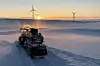 Snøscooter i solnedgang i Hamnefjellet vindkraftverk i Båtsfjord.
