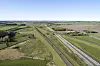 Sør for byen skal den nye motorveien koble seg på dagens E45. Byen Aalborg i det fjerne. Illustrasjon: Vejdirektoratet/Mikkel Barker ApS