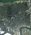 Sentrum av New Orleans fotogrfaert dagen etter at Katrina feide over. De lyse partier på veier er bygget på pæler og ligger over vann, mens de fleste sentrumsgater er oversvømmet. Skadeomfanget er enormt. Elva Mississippi sees nederst til høyre.