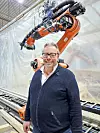 Gunnar Adolf Aanesland viser stolt frem en av robotene de bruker til å forme treverket. Foto: Tuva Sæbø Egeland