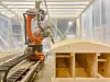 Roboten står i en plastkapsling midt i produksjonshallen. Foto: Tuva Sæbø Egeland