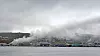 Det brenner fremdeles kraftig på den russiske tråleren ved kai i Breivika Havn i Tromsø. Universitetssykehuset i Nord-Norge ligger i røyken fra båten.