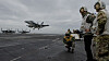NATOs generalsekretær Jens Stoltenberg ser på mens et F-18 Super Hornet-fly lander på det amerikanske hangarskipet USS Harry S. Truman, som skal delta i NATO-øvelsen Trident Juncture.