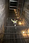 Ned denne tretti meter dype sjakten ble røykviftene til Nationaltheatret stasjon firet ned, så videre på en skrårampe til stedet de skulle monteres over perrongen.