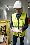 Sekunder tidligere var dette flytende glass. Det blir spunnet som sukkerspinn til syltynne, lange tråder av glass. Fabrikksjef Jan Dag Aaeninspiserer konsistensen før materialet samles til en matte.