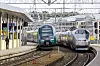 Flytoget får nå samme eier som Vy. Her står et Vy-tog til venstre, og et Flytoget-tog til høyre. Bildet er fra mars i år.