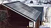 Gårdsbygning med solcellepanel på taket.