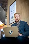 Halvor Singh-Evensen forteller stolt om Cloudians nye GPUDirect-støtte mens han venter på flytogets neste avgang. Foto: TUM Studio