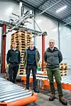 Her er det første eksemplaret av pallsorteringsroboten «Sort» montert på varelageret til dagligvaregrossisten H.I. Giørtz på Eidsnes utenfor Ålesund. Daglig leder Torbjørn Krogen til høyre sammen med software-utviklerne Thomas Sund Mjåland og Rasmus Nes Tjørstad. Foto: Currence Robotics