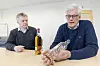 Jens Lehrmann (til venstre), administrerende direktør, og teknologidirektør Stian Sannes i Seram Coatings har solgt pulveret til en produsent som lager flasker til en whiskyprodusent. Løsningen gir betydelig redusert svinn under produksjonen, hevder de. Flasken Sannes viser frem er produsert ved å bruke deres produkt i flaskeformen. Foto: Arash A. Nejad