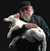 George RR. Martin, skaperen av A Song of Ice and Fire, med en skrekkulv. Den utdødde rasen ga inspirasjon til «hans» dire wolfs. Foto: Colossal Biosciences