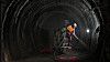 En arbeider sprayer et lag med sement som beskyttelse i en tunnel for radioaktivt avfall i Bure.