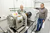 Gründer Per Øhlckers (til venstre) og påtroppende sjef Egill Elvestad i Nanocaps viser en av maskinene de bruker i den videre utviklingen. Foto: Arash Nejad