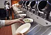 Restauranten Spyce i Boston bruker maskiner til å lage mat. Her henter en av de ansatte en lunsjrett fra produksjonslinjen. Foto: Charles Krupa / AP / NTB scanpix