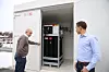 Geir Christensen og Andreas Reason Dahl viser containeren med hydrogen på baksiden av bygget til Kongsberg Maritime. Foto: Tore Stensvold