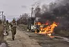 Ukrainske soldater passerer en brennende buss som har blitt truffet av en russisk drone nær Bakhmut i Dontesk-regionen i 2023.