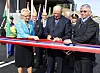 Kong Harald klipper snoren som markerer den offisille åpningen av E 18-parsellen mellom Grimstad og Kristiansand i 2009. Til venstre daværende samferdselsminister Liv Signe Navarsete og til høyre veidirektør Terje Moe Gustavsen. Foto: