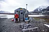 Imponert: Kommunal- og moderniseringsminister Jan Tore Sanner var i oktober i Ny-Ålesund for å legge grunnsteinen for det nye 300-millioners observatoriet. – Dette er langt viktigere enn de fleste av oss egentlig forstår. Dataene som samles inn her er helt avgjørende for GPS, navigasjon, miljøovervåking og forskning, sier han. Her er Sanner ved en av hyttene innbyggerne i Ny-Ålesund disponerer fritt. Foto: Eirik Helland Urke