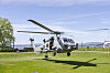 Et helikopter lander på en gressplen.