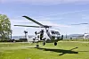 Et helikopter lander på en gressplen.